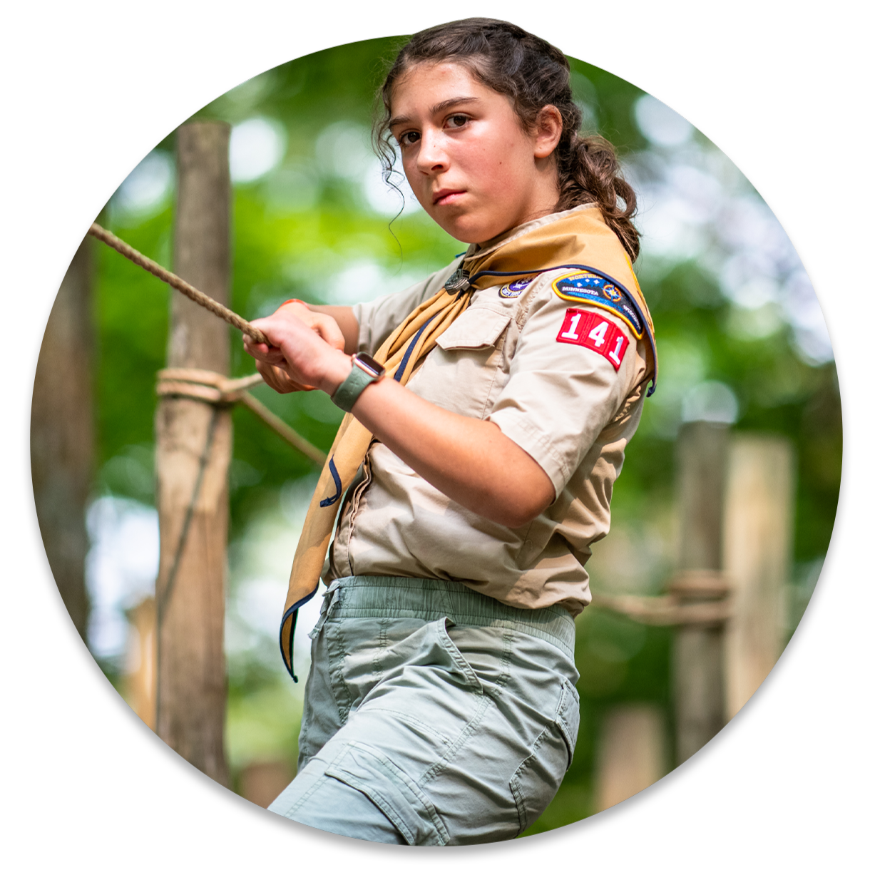 A teenage girl with a serious expression navigates a lashed obstacle course
