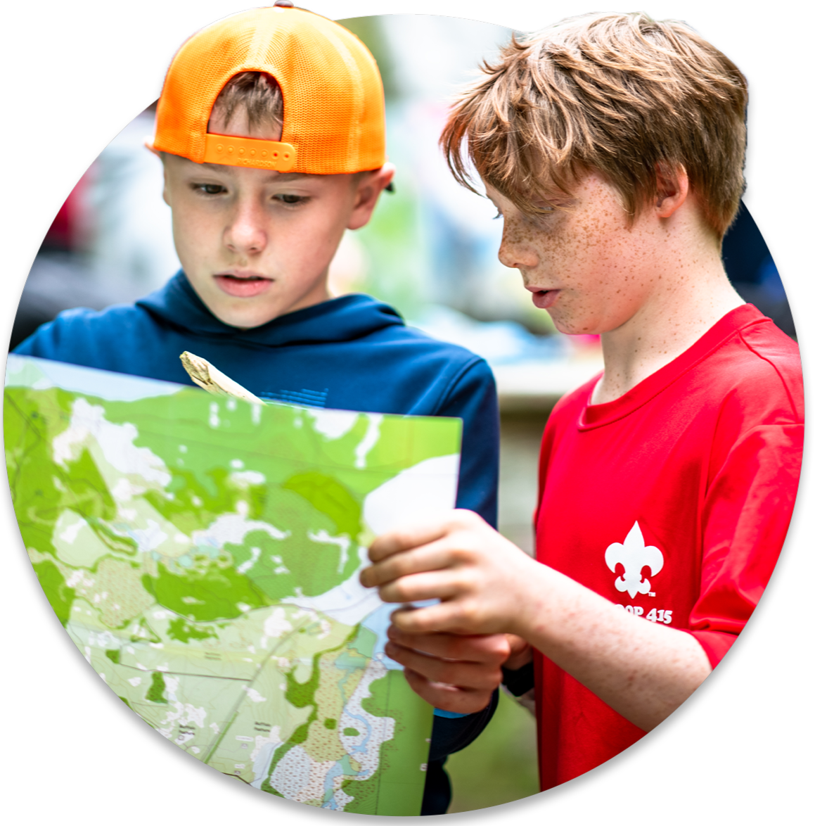 Two young boys are looking at and discussing what's on a map